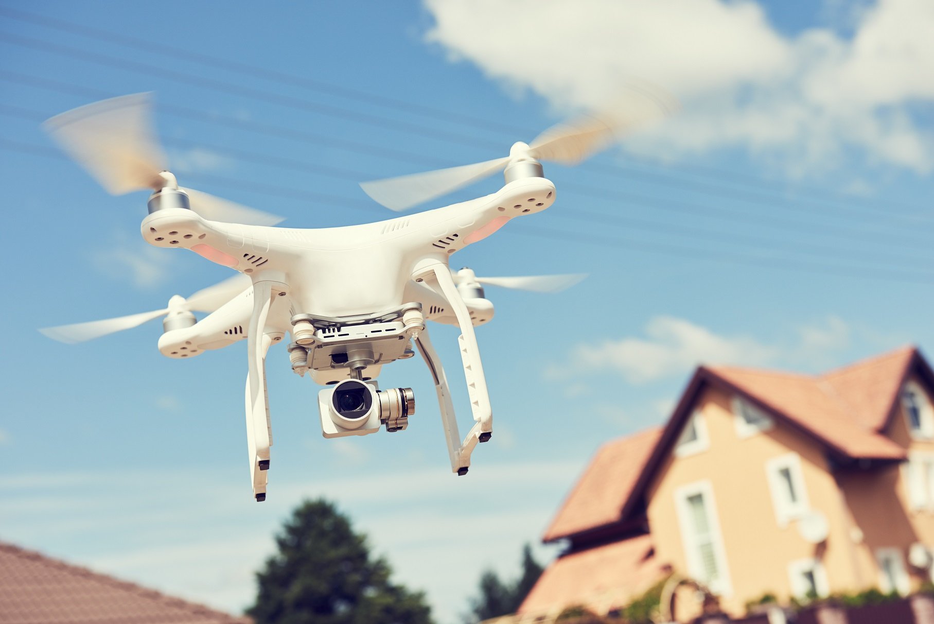 Drohne fliegt, Häuser im Hintergrund