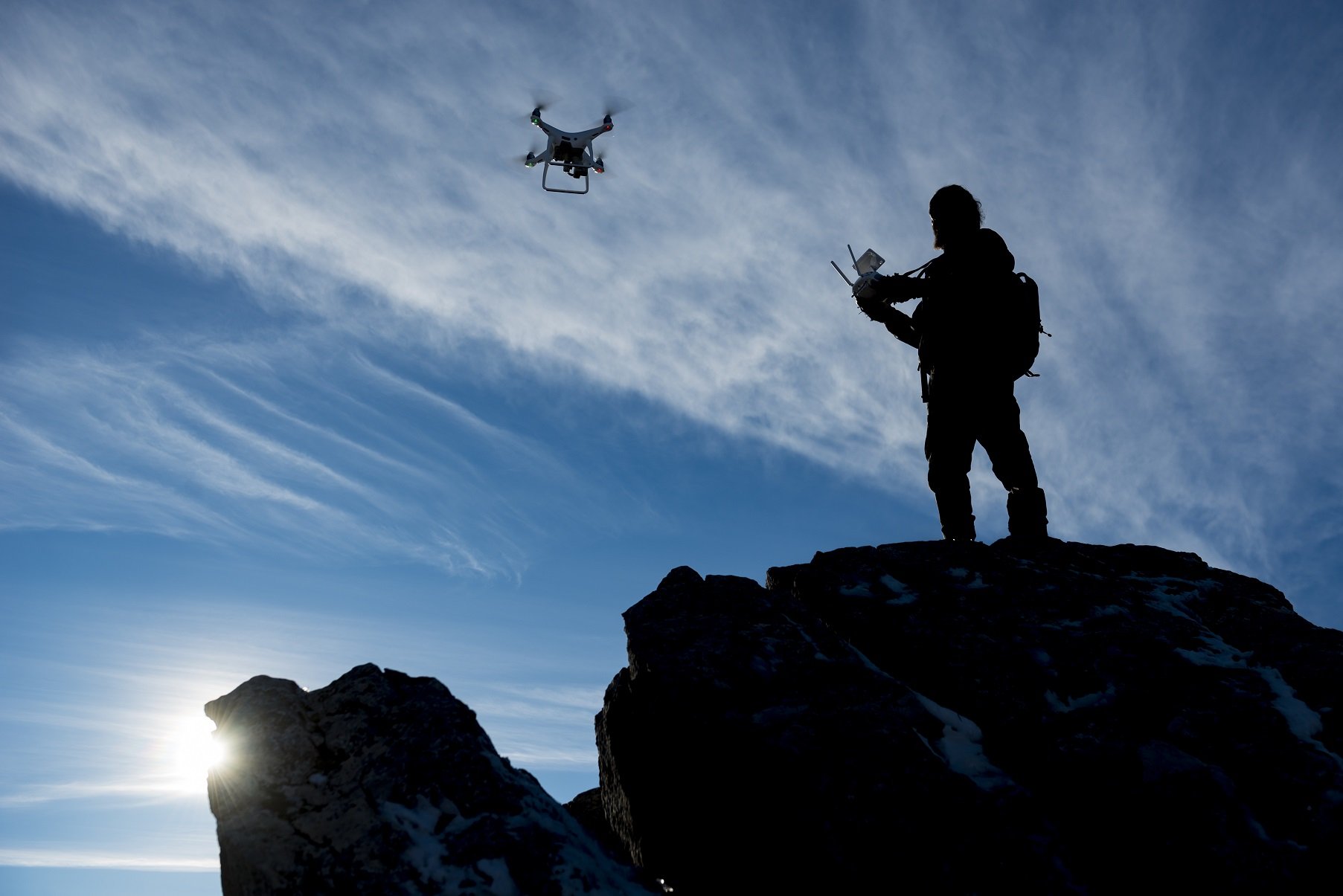 Person fliegt Drohne auf Berg